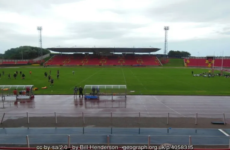Góc nhìn từ khán đài sân Gateshead International, thấy rõ khu vực ghế ngồi và đường chạy điền kinh bao quanh sân bóng.