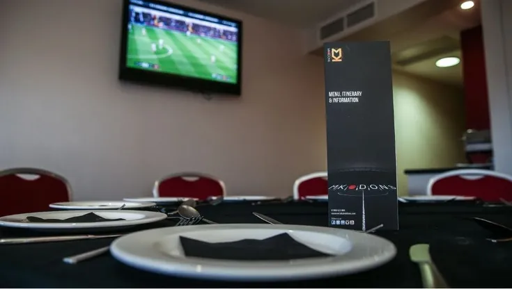 Không gian dịch vụ hospitality cao cấp tại Stadium MK, với bàn ăn và view sân cỏ