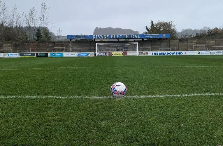 Khu khán đài đứng (terrace) tại The Meadow, sân nhà của Chesham United, thể hiện không gian mở và gần gũi với cầu thủ.