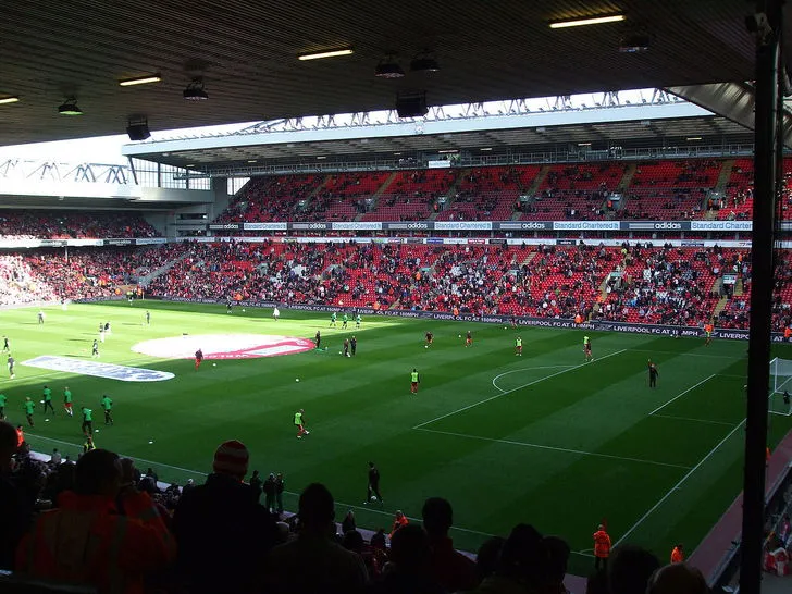 Khung cảnh bên trong sân Anfield với khán đài và mặt cỏ xanh mướt, chuẩn bị cho một trận đấu Ngoại hạng Anh