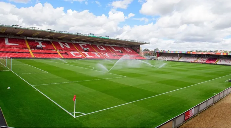 Toàn cảnh mặt cỏ xanh mướt và khán đài của sân Sincil Bank, biểu tượng của Lincoln City FC