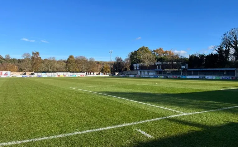 Toàn cảnh sân bóng The Meadow của Chesham United, với mặt cỏ xanh mướt và không gian xung quanh sân.